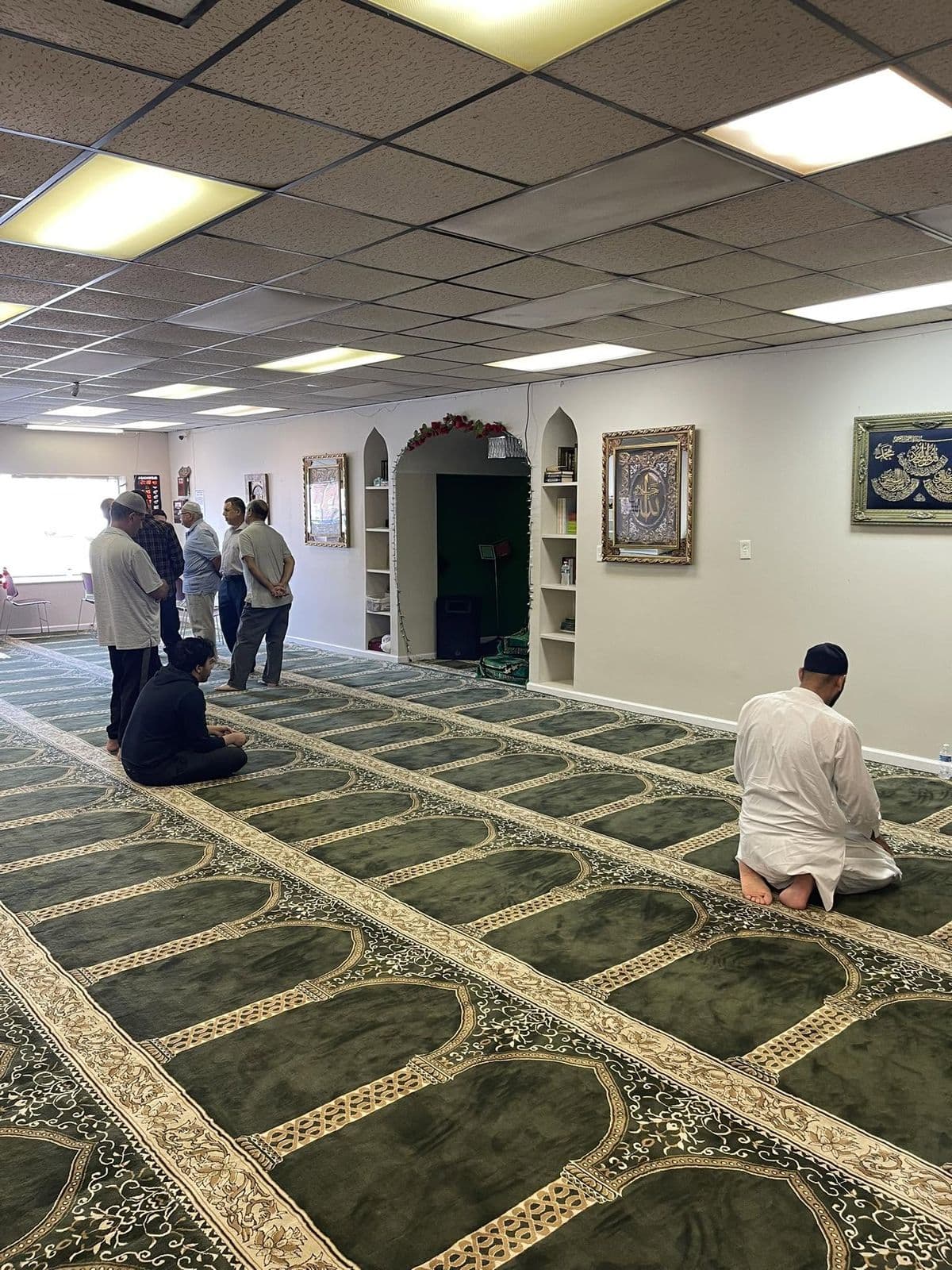 Prayer hall at the Islamic Center of Lynchburg with deep green carpet and gold arch patterns